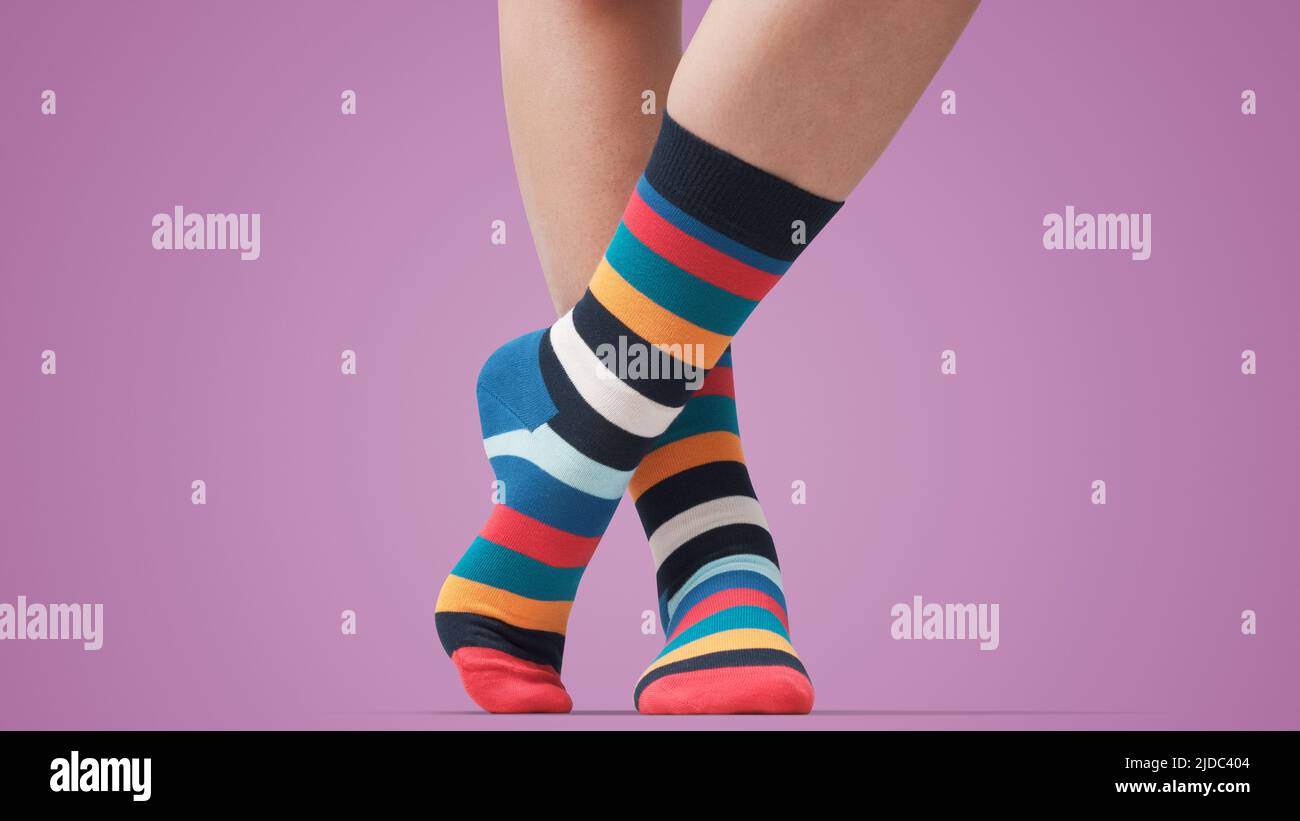 Modello in posa con calzini colorati a righe e in piedi, piedi da vicino Foto Stock