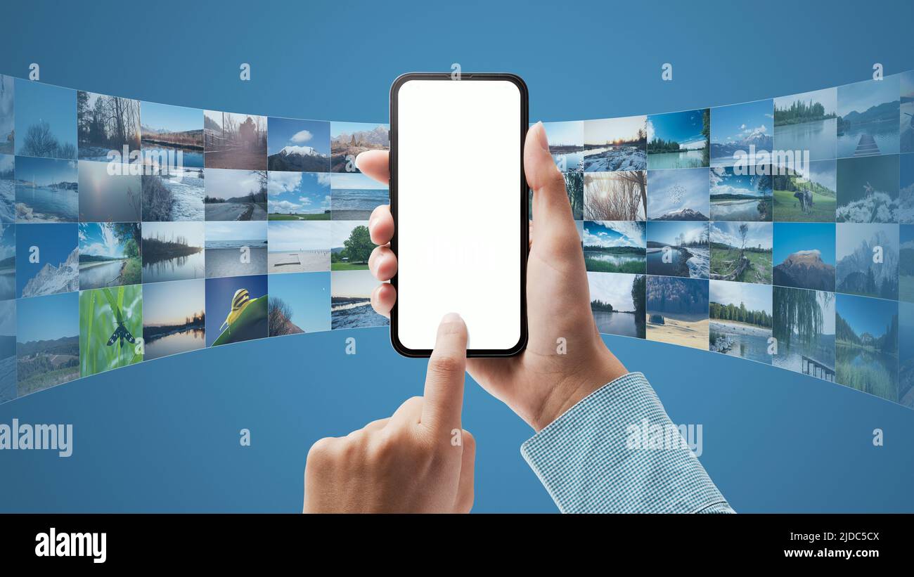 Tenendo uno smartphone e un'applicazione basata su cloud, l'utente sta scaricando i dati sul dispositivo, POV shot Foto Stock