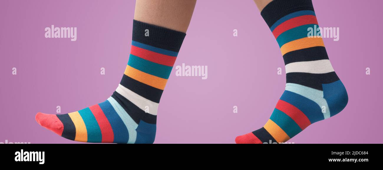 Modello in posa con calzini colorati a strisce e camminare, piedi da vicino Foto Stock