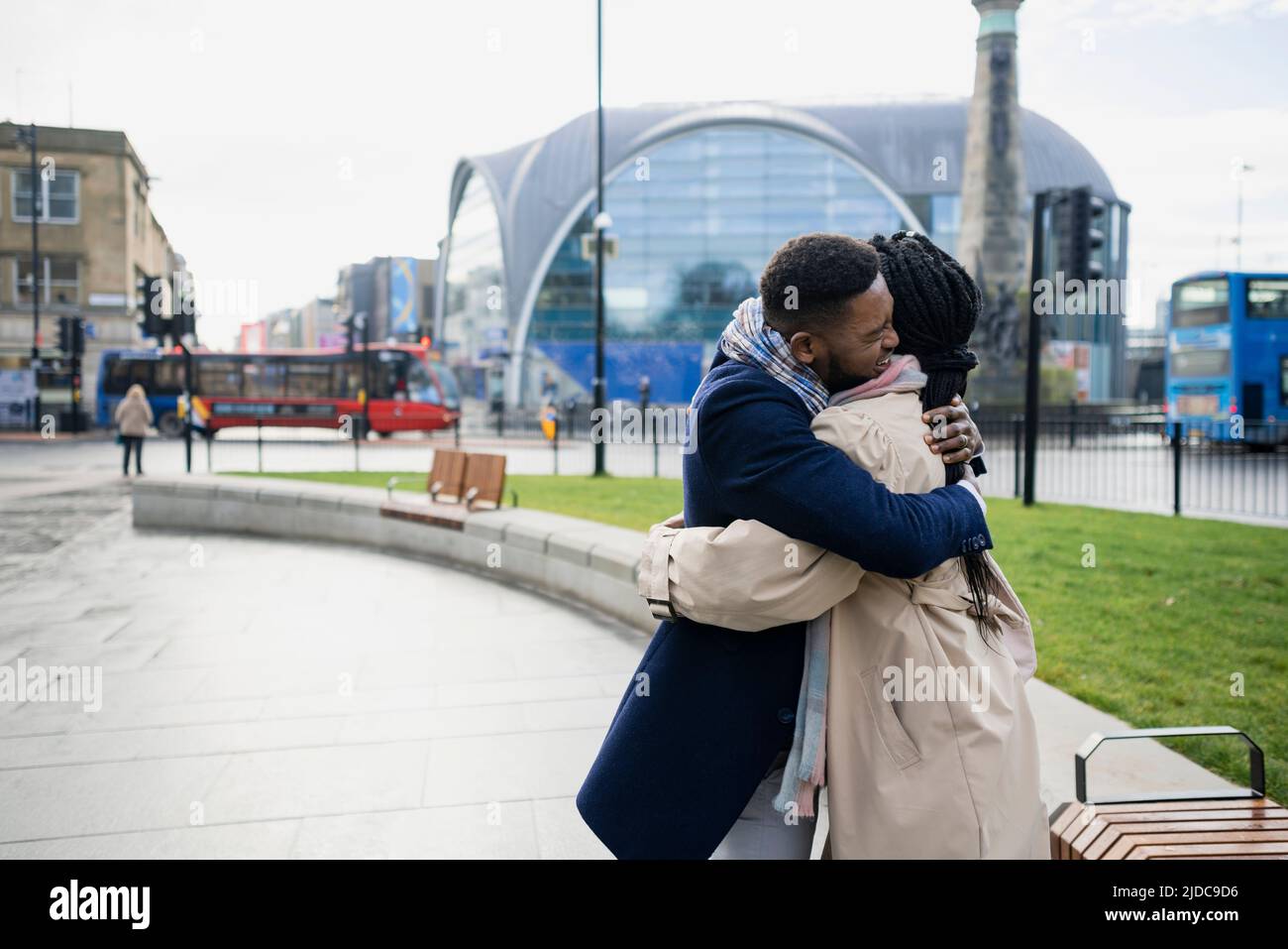 Coppia abbracciando con le braccia intorno l'un l'altro in città Foto Stock