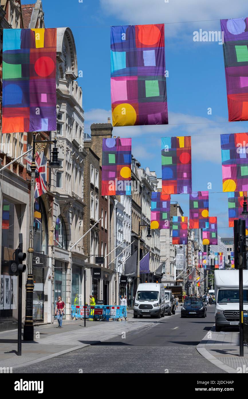 New Bond Street, Londra, Regno Unito. 20th giugno 2022. Bandiere colorate disegnate da Mali Morris RA appendere sopra New Bond Street celebrando l'arte a Mayfair e la mostra estiva RA. Credit: Malcolm Park/Alamy Live News Foto Stock