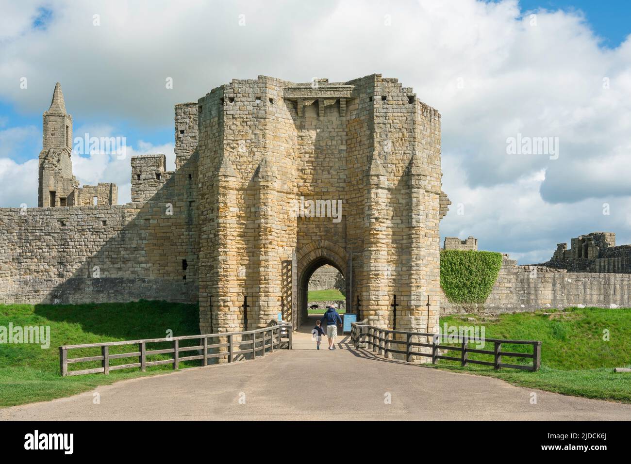 Padre figlio, vista posteriore di un padre che porta suo figlio a visitare un castello medievale in una giornata di sole, Northumberland, Inghilterra, Regno Unito Foto Stock