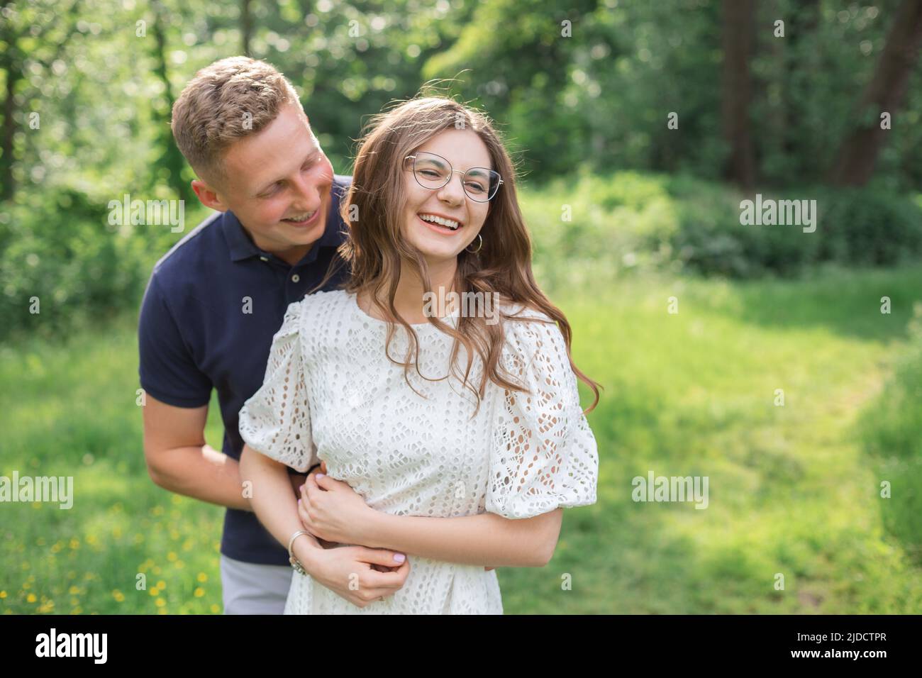 Momenti romantici di felice coppia europea in amore godersi la vacanza nel parco. Abbracciando e divertendosi insieme. Foto Stock