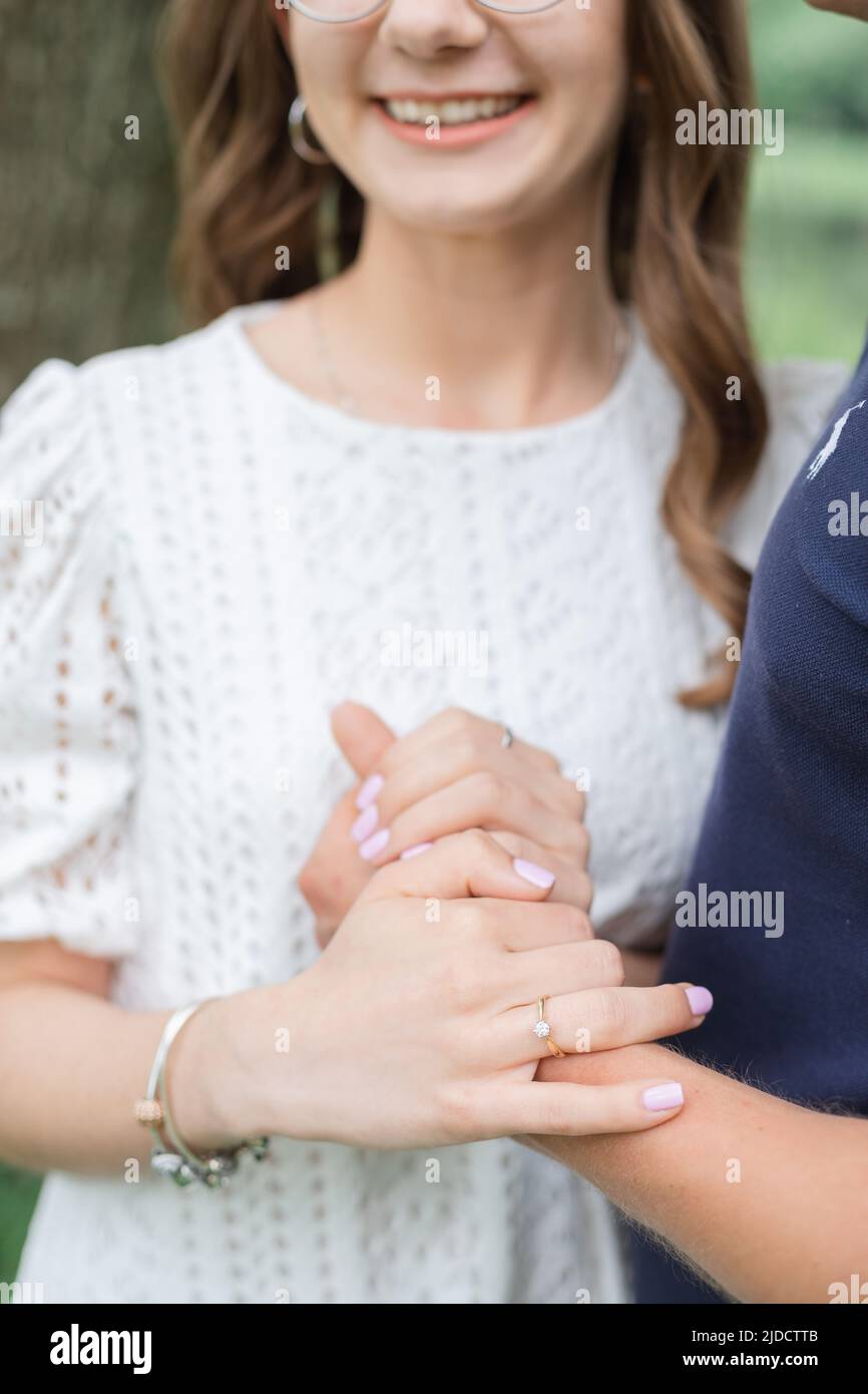 Ritratto di giovane coppia romantica che si abbraccia, sorridendo, godendo la giornata estiva nel parco. Donna uomo che si innamora. Persone irriconoscibili Foto Stock