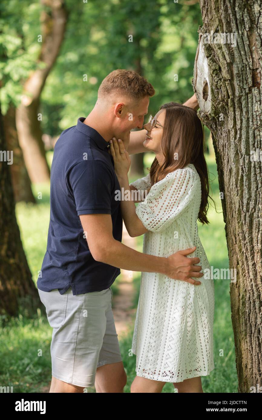 Ritratto di bella coppia felice guardando l'un l'altro nel parco estivo, uomo abbracciando donna Foto Stock