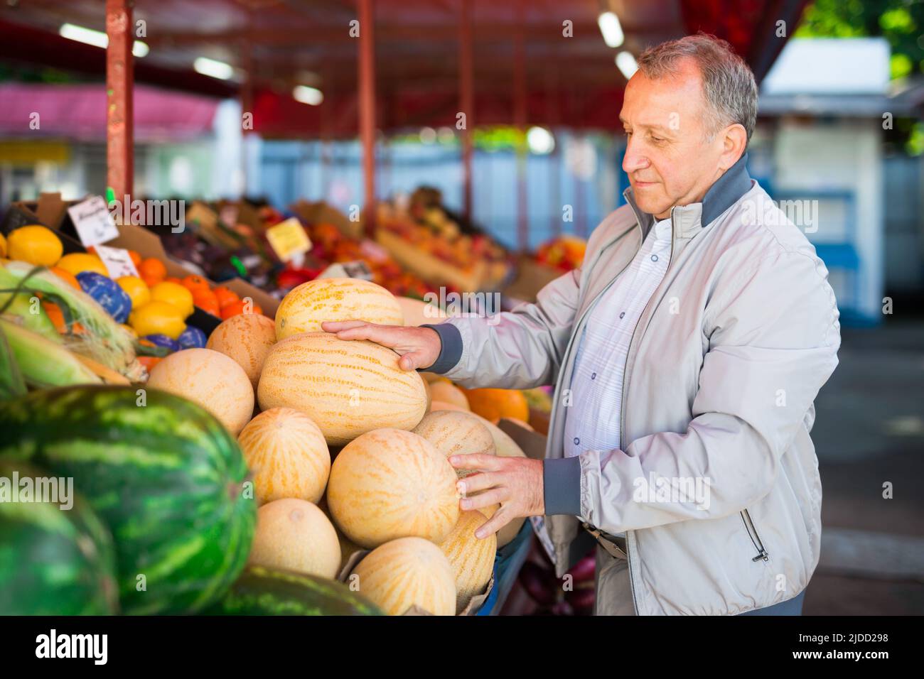 Uomo di mezza età che acquista melone Foto Stock