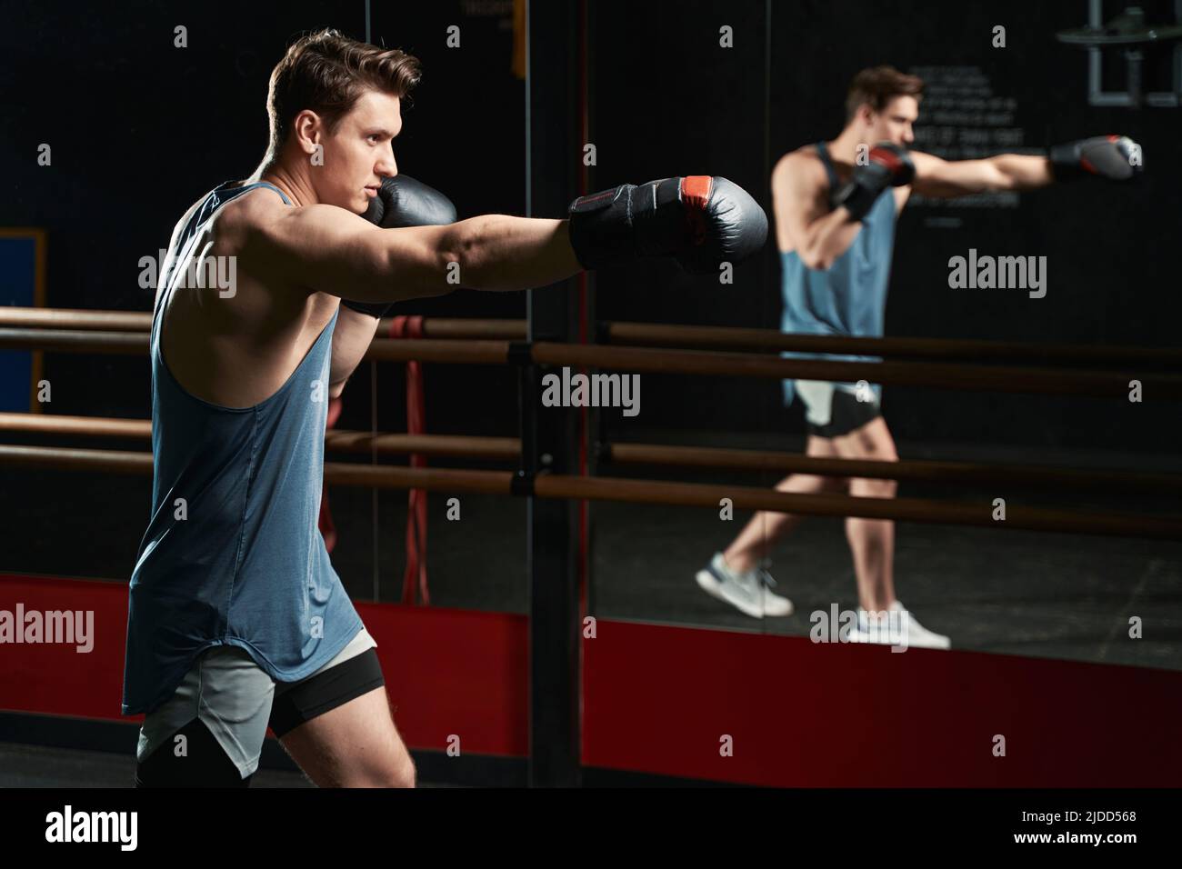 Giovane uomo muscoloso che si allena in palestra Foto Stock
