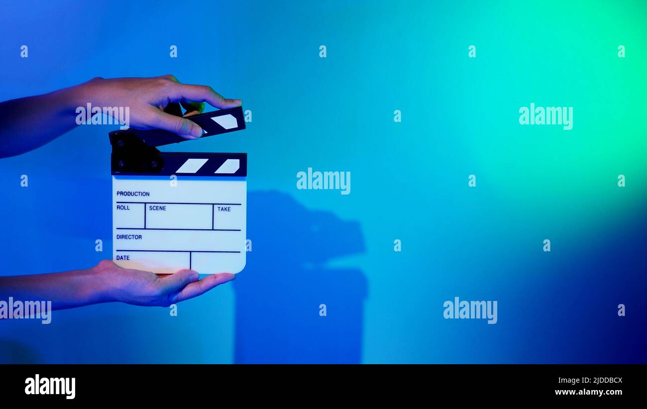 Scheda Clapper del film. La mano dell'equipaggio tiene il pannello in ardesia con pellicola di legno e plastica contro la fotocamera. Clapperboard di film usando nella produzione di video e nella vite prigioniera di film Foto Stock