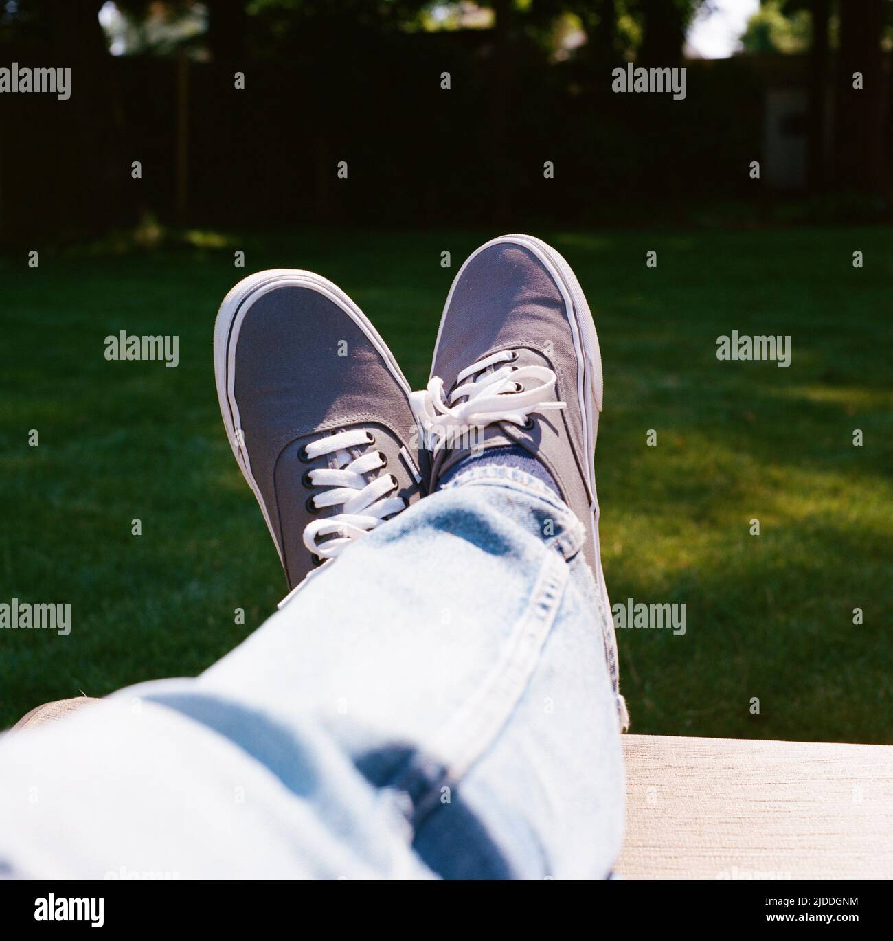Facile da portare con i piedi in su nel cortile indossando Sneakers Foto Stock