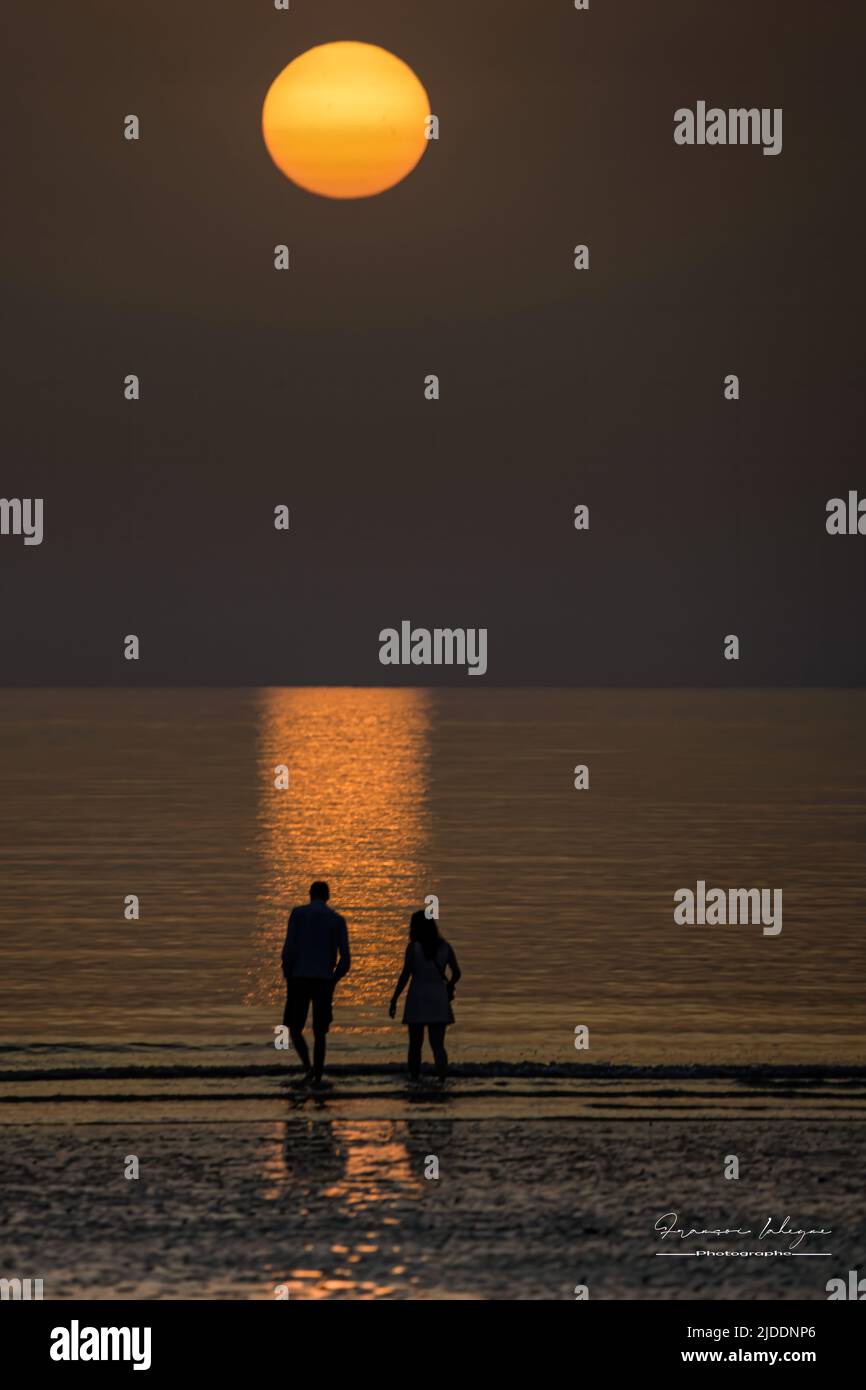 Coucher de soleil Ault Onival, personnes au bord de l'eau, soleil sur la mer, pêcheur crevette Foto Stock