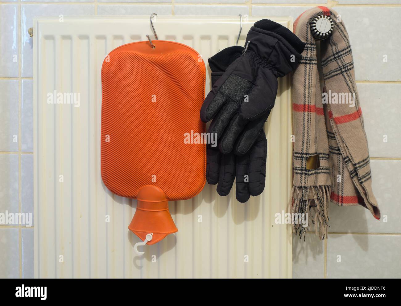 Radiatore, bottiglia di riscaldamento, sciarpa e guanti caldi, mancanza di gas di riscaldamento a causa dell'embargo russo petrolio e gas in europa Foto Stock