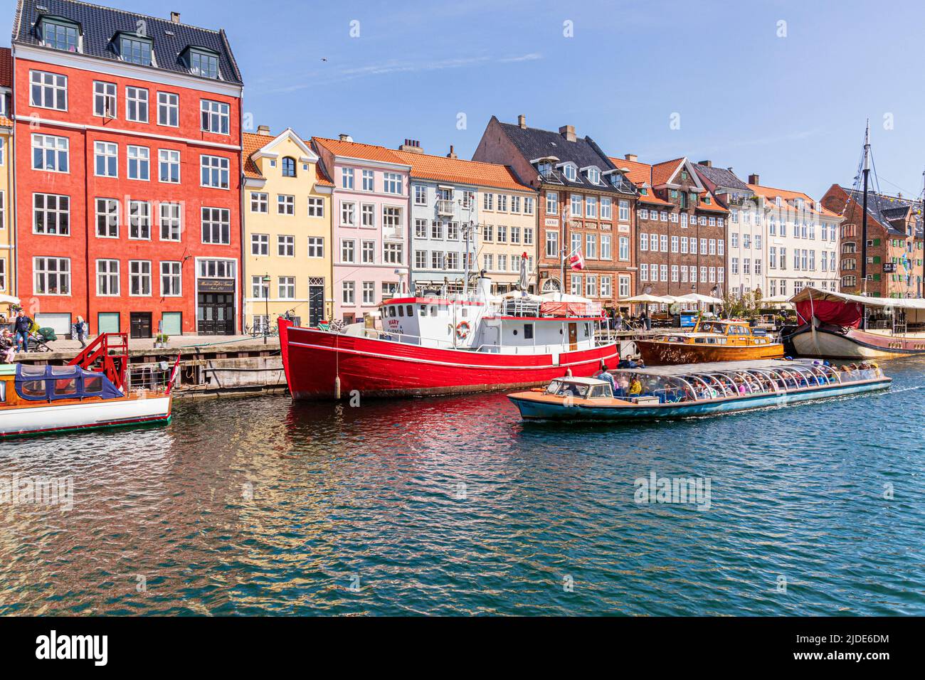 Un tour turistico in barca che passa Nyhavn, il colorato lungomare del canale del 17th secolo a Copenhagen, Danimarca. Foto Stock