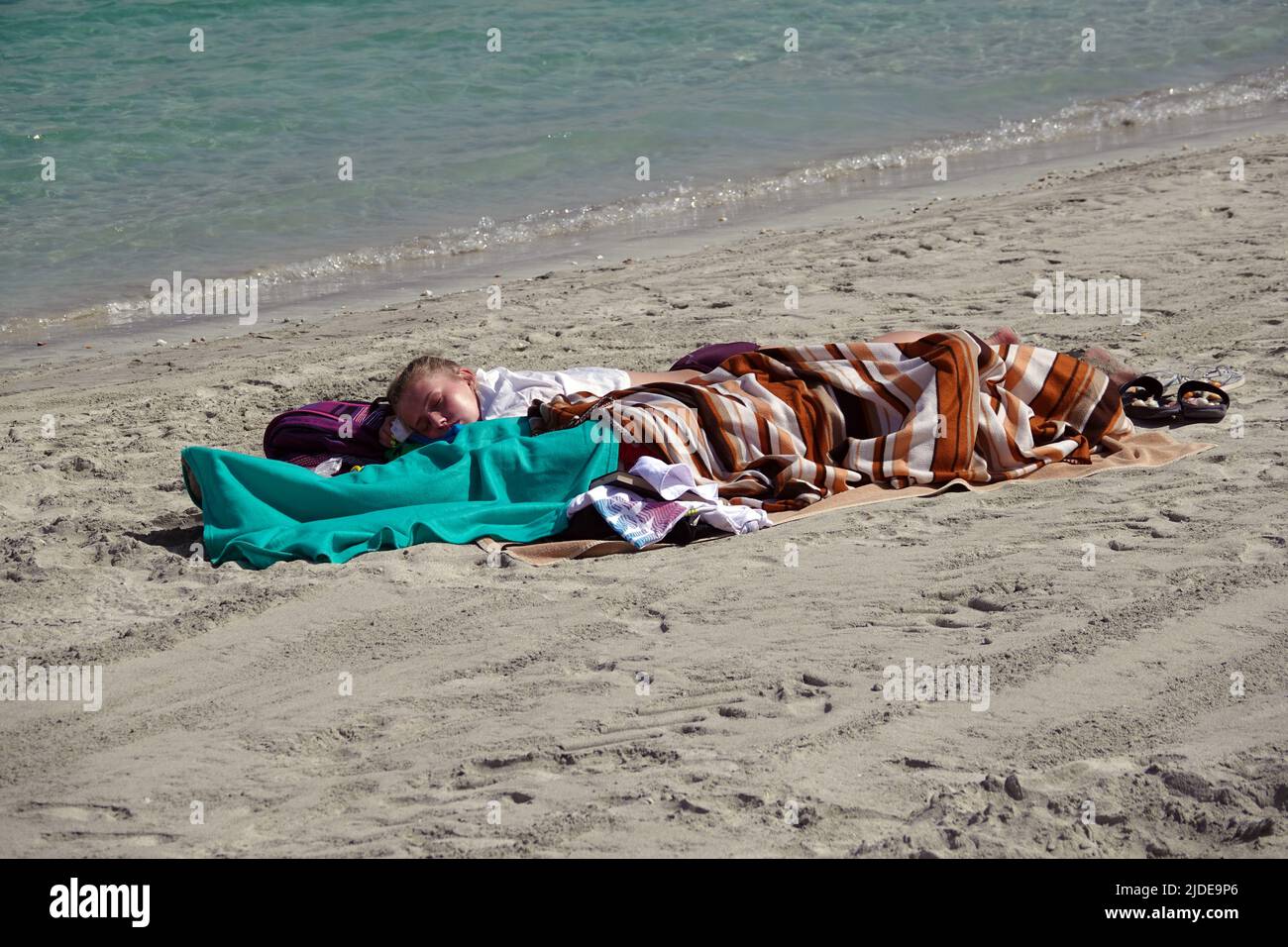 Sharjah, UAE 25 febbraio 2020: I turisti chiudevano completamente dal sole che corbola sulla spiaggia Foto Stock