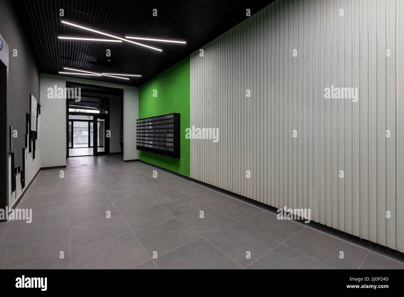 Corridoio interno, con porta d'ingresso e ascensore in molti appartamenti, con cassette postali con pareti verdi Foto Stock