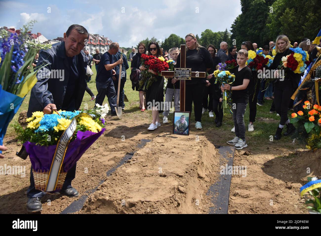 Lviv, Ucraina. 17th giugno 2022. La gente deposita fiori alla tomba di un soldato ucraino caduto durante la cerimonia funebre a Lviv. Cerimonia funeraria del tenente superiore Serhiy Spodarenko e del sergente junior Ivan Kerdman, morto in battaglia con le truppe russe a Lviv. (Foto di Pavlo Palamarchuk/SOPA Images/Sipa USA) Credit: Sipa USA/Alamy Live News Foto Stock