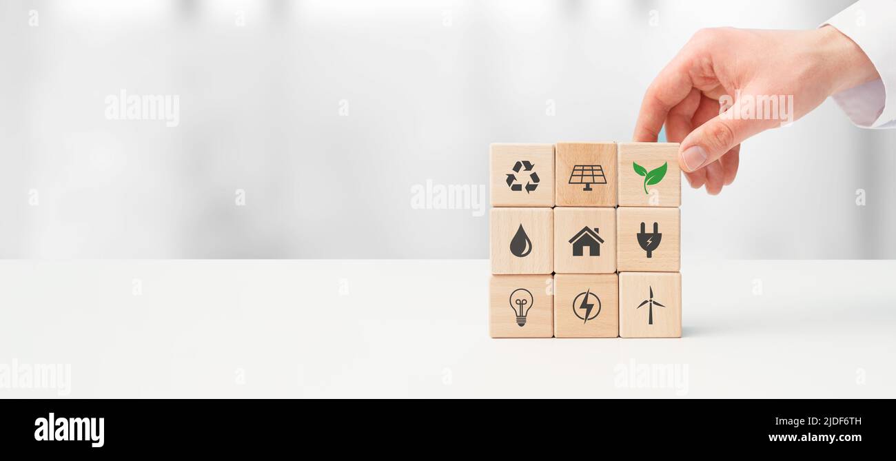 Tutela dell'ambiente, fonti energetiche rinnovabili e sostenibili. Mano fissa blocchi con simboli di energia rinnovabile Foto Stock