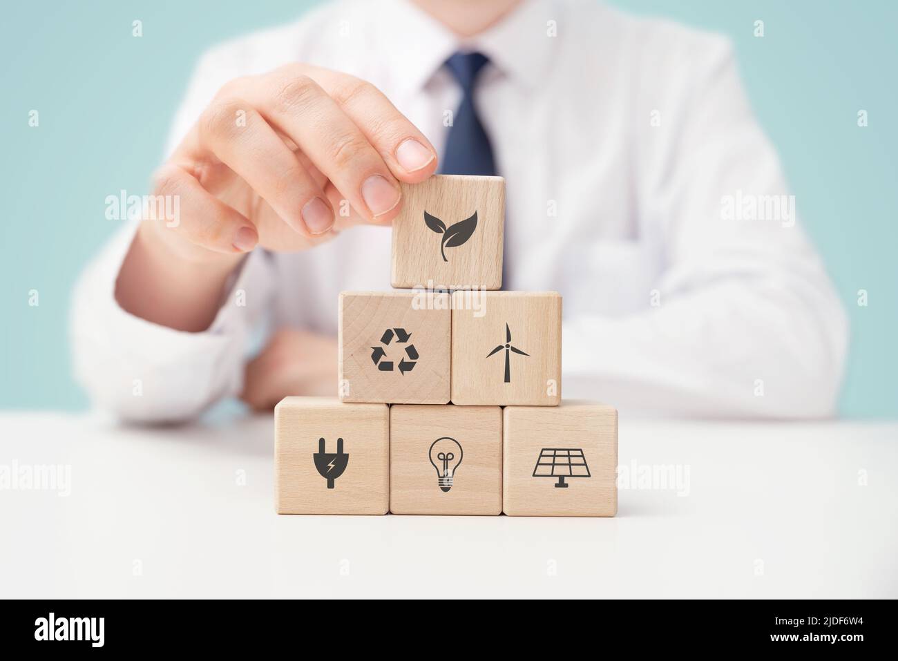 Tutela dell'ambiente, fonti energetiche rinnovabili e sostenibili. Mano fissa blocchi con simboli di energia rinnovabile Foto Stock