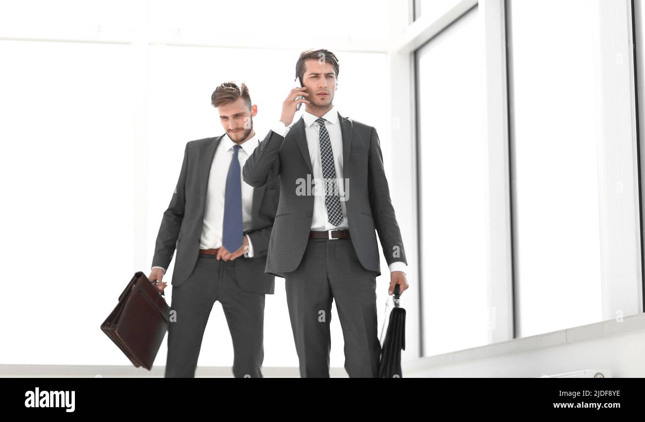 i colleghi di lavoro passano attraverso un ufficio spazioso Foto Stock