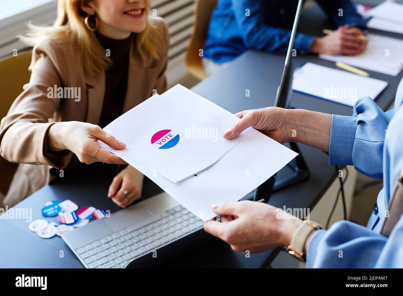 Primo piano della giovane donna che ha consegnato ballottaggi e adesivi Voter il giorno delle elezioni, spazio copia Foto Stock