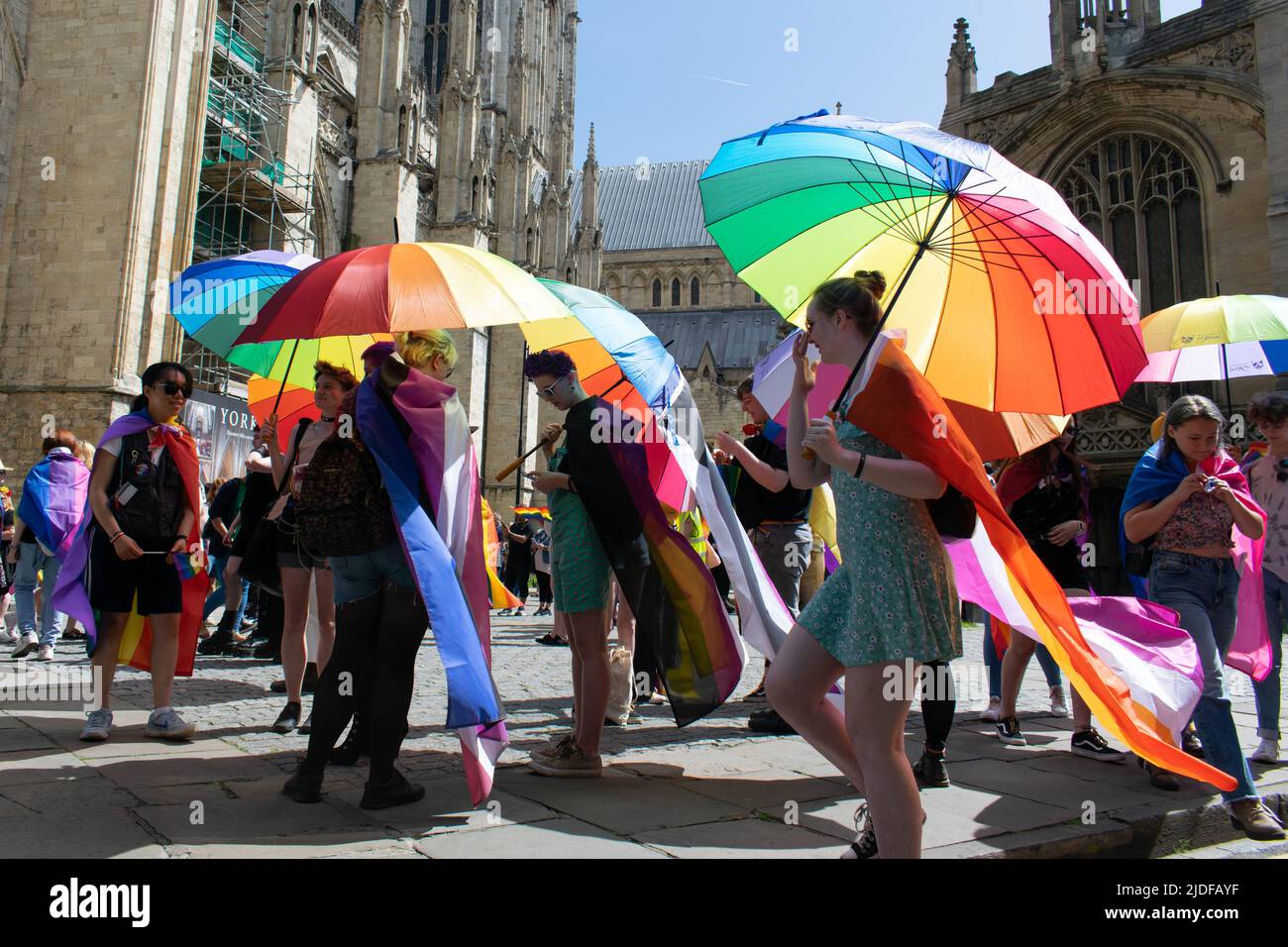 York Pride Parade con ombrello arcobaleno di fronte a York Minster, Yorkshire, Regno Unito Foto Stock