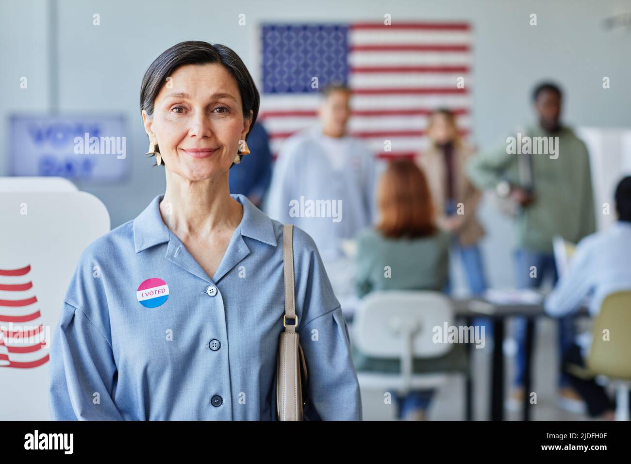 Vita su ritratto di donna matura sorridente con ho votato adesivo in posa il giorno delle elezioni, spazio copia Foto Stock