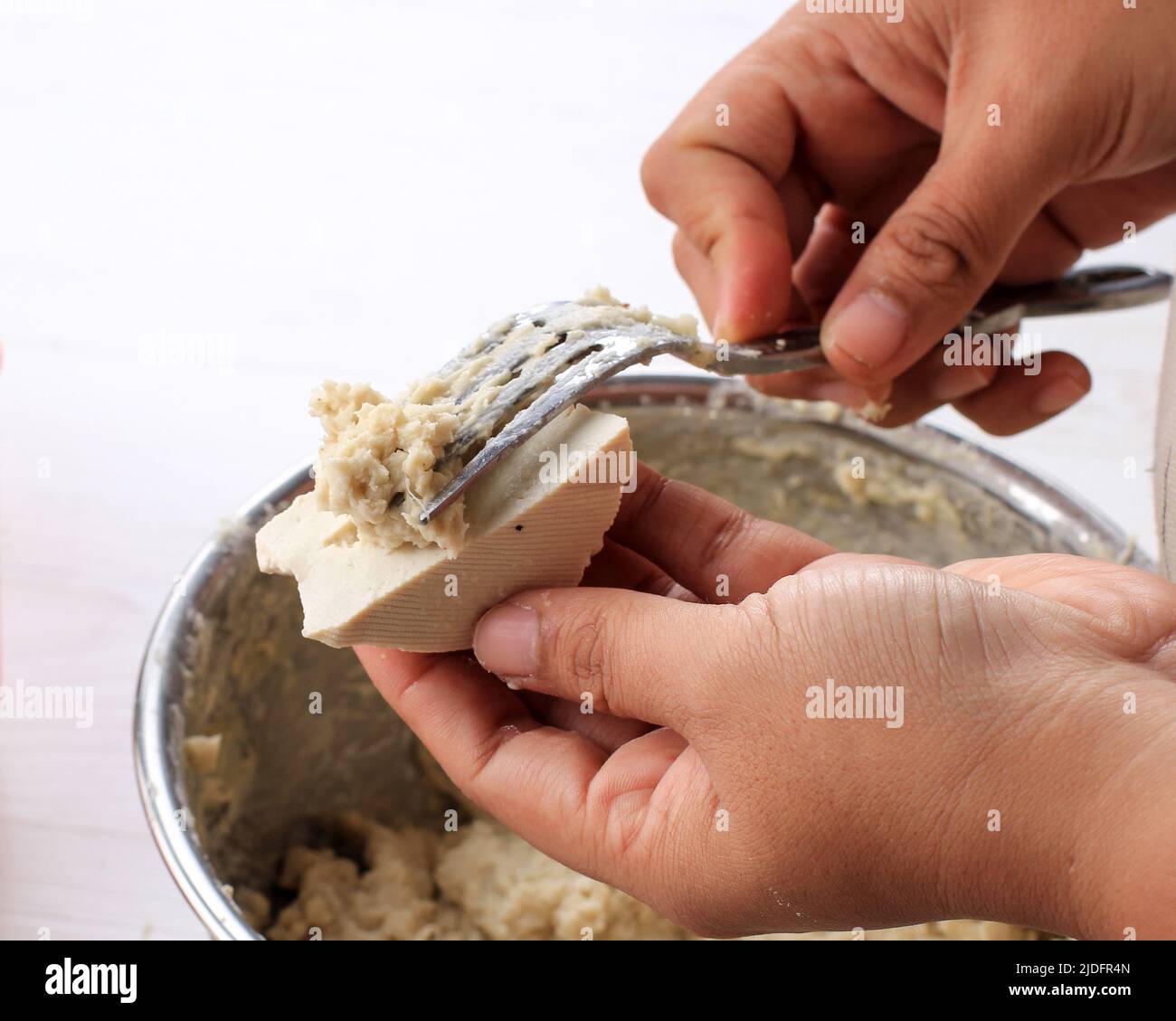 Processo di cottura, Tofu ripieni con batter di pesce che fa Baso Tahu Goreng (Batagor) o Siomay Bandung, popolare Street Food in Indonesia. Una mano donna usi Foto Stock