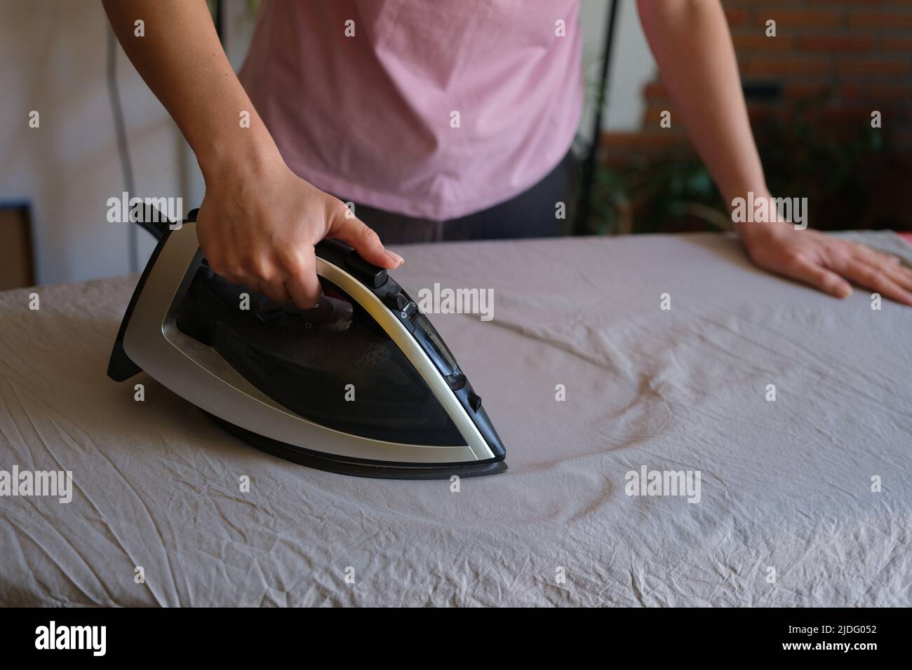 Casalinga stira stirare la lenzuola stropicciata a bordo utilizzando ferro  da stiro a vapore Foto stock - Alamy