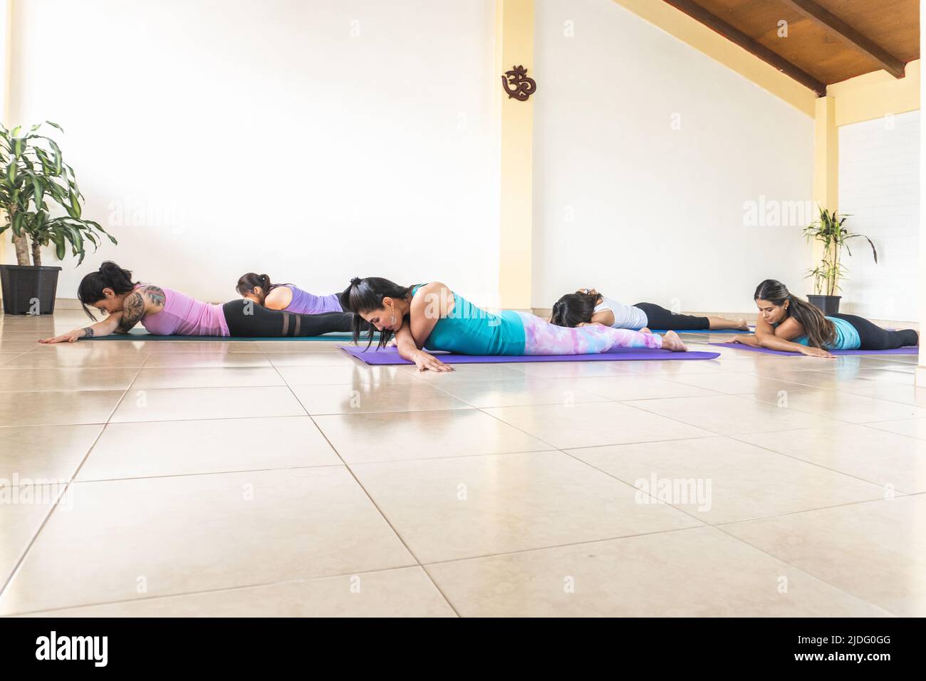 le donne che praticano lo yoga e il relax sono a faccia in giù nello studio Foto Stock