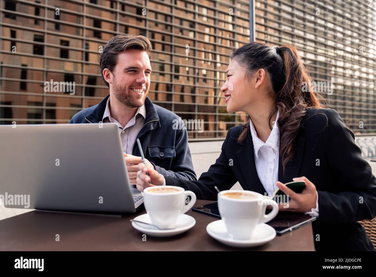 donna e uomo che lavorano con un computer portatile su una terrazza Foto Stock