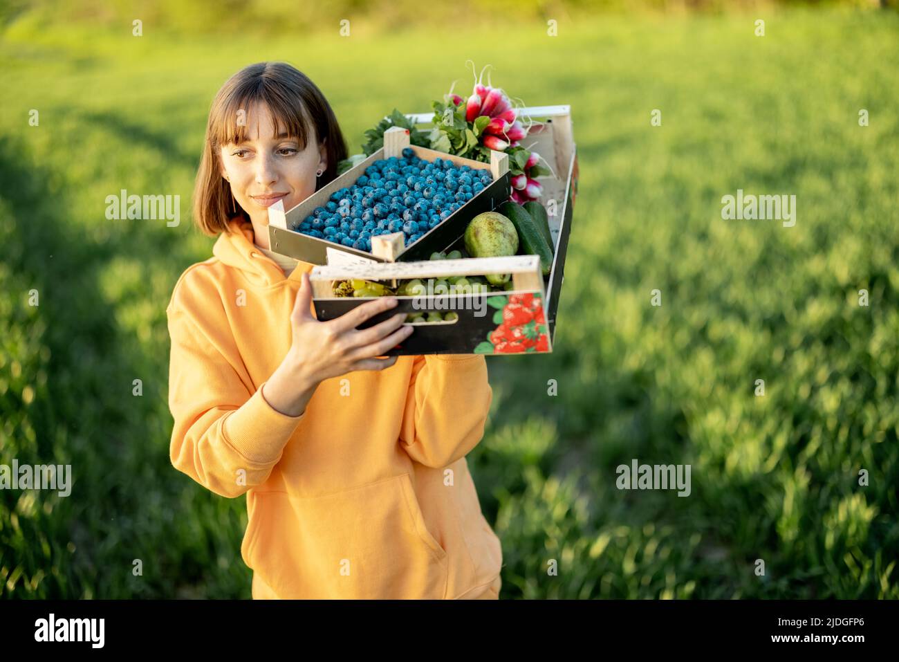 Donna con cibo fresco in campagna Foto Stock