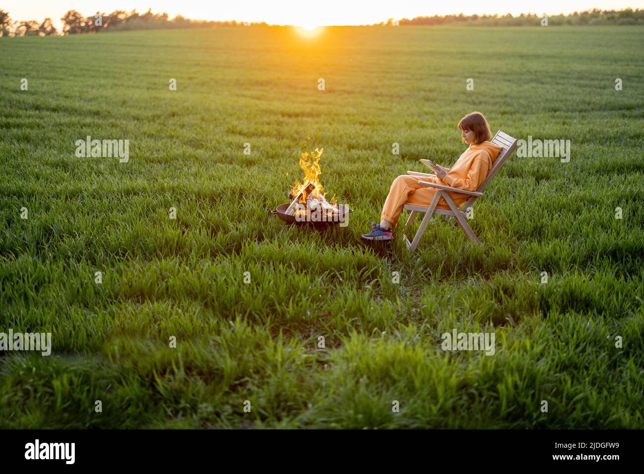 Donna relax vicino al camino con il suo cane sul campo Foto Stock