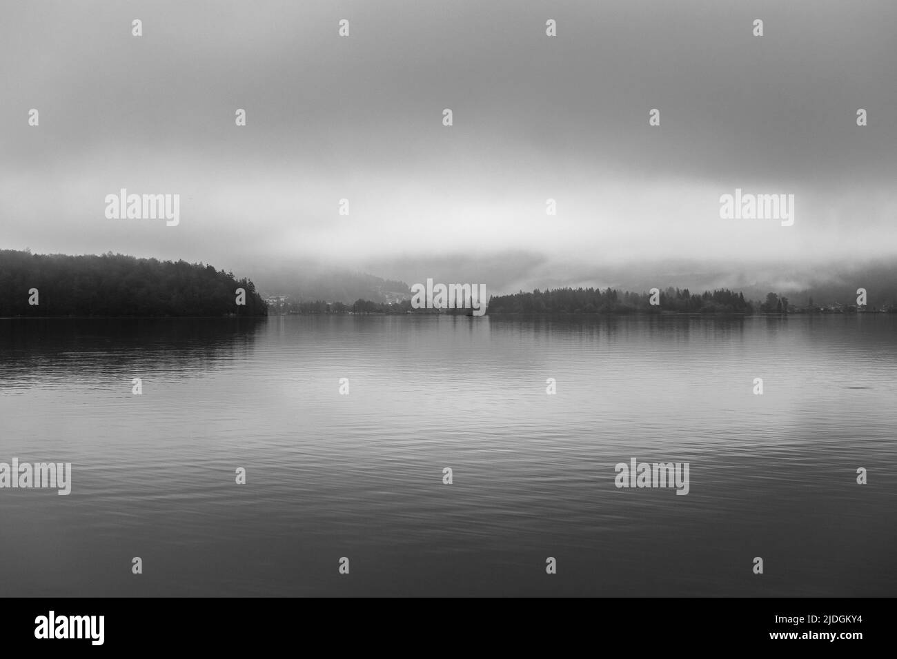 Vista sul lago Hallstatt (Hallstatter See) nella zona di Salzkammergut. Le nuvole e la nebbia si riflettono. Gmunden. Austria. Europa. Bianco e nero orizzontale. Foto Stock