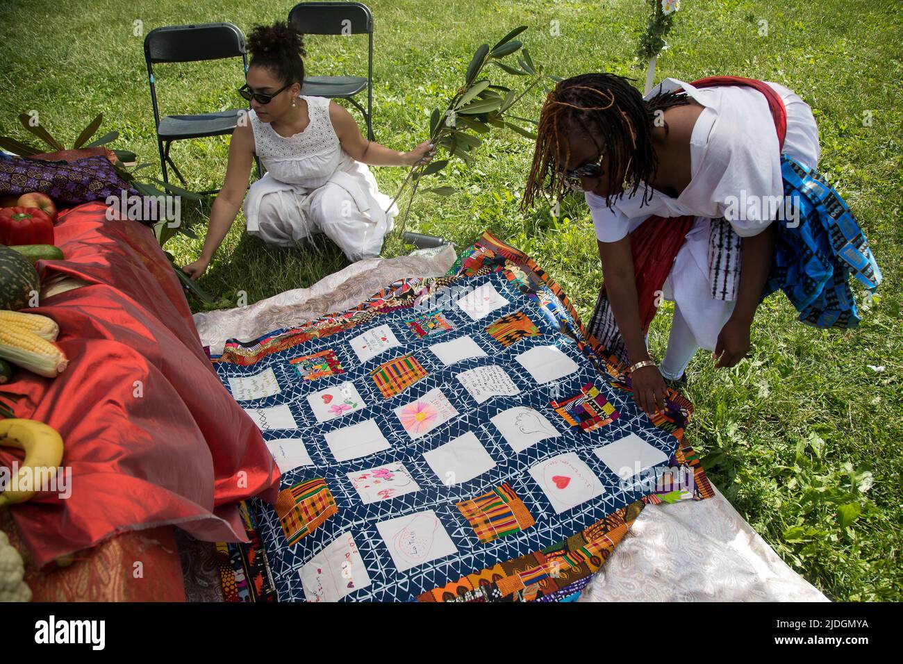 NEW YORK, 21 giugno 2022 (Xinhua) -- Chayanne Marcano (L) e Catherine Mbali Green-Johnson, curatori del progetto trapunta, pongono una quilt memorializzante le vittime della pandemia COVID-19 durante il 13th annuale Junetseicentesimo Festival a Prospect Park nel quartiere Brooklyn di New York, Stati Uniti, il 19 giugno 2022. I partecipanti hanno fatto opere d'arte o scritto parole sui trapunte in commemorazione dei loro familiari morti del coronavirus. Mentre gli afro-americani a New York si unirono ad altri provenienti da tutto il paese per commemorare la fine della schiavitù negli Stati Uniti, anche loro hanno hono Foto Stock