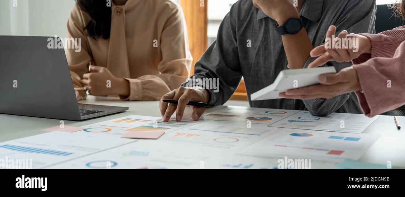 Business People Meeting idee di progettazione concetto. Gruppo di investitori diversi brainstorming e puntando al computer portatile sulla scrivania in legno. Foto Stock