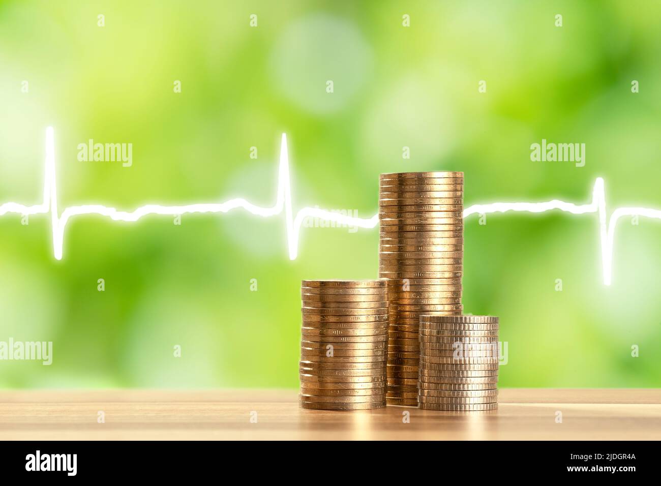 Primo piano foto di monete impilate e frequenza cardiaca come simbolo di assistenza sanitaria. Concetto di aumento dei costi di assistenza sanitaria e di assicurazione. Foto Stock