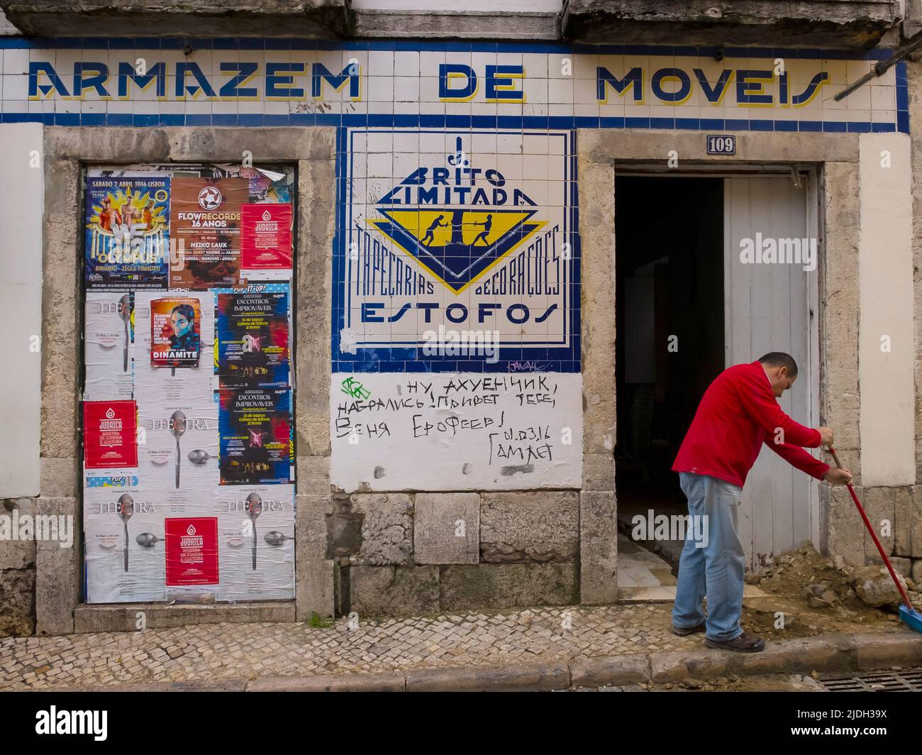 Uomo che si trova di fronte ad un magazzino di mobili, Armazem de Moveis, Portogallo, Lisbona Foto Stock