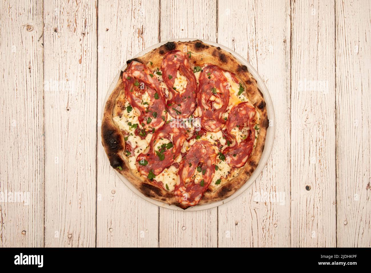 Pizza Diavola con mozzarella e prezzemolo fresco tritato cotto in forno a  pietra Foto stock - Alamy