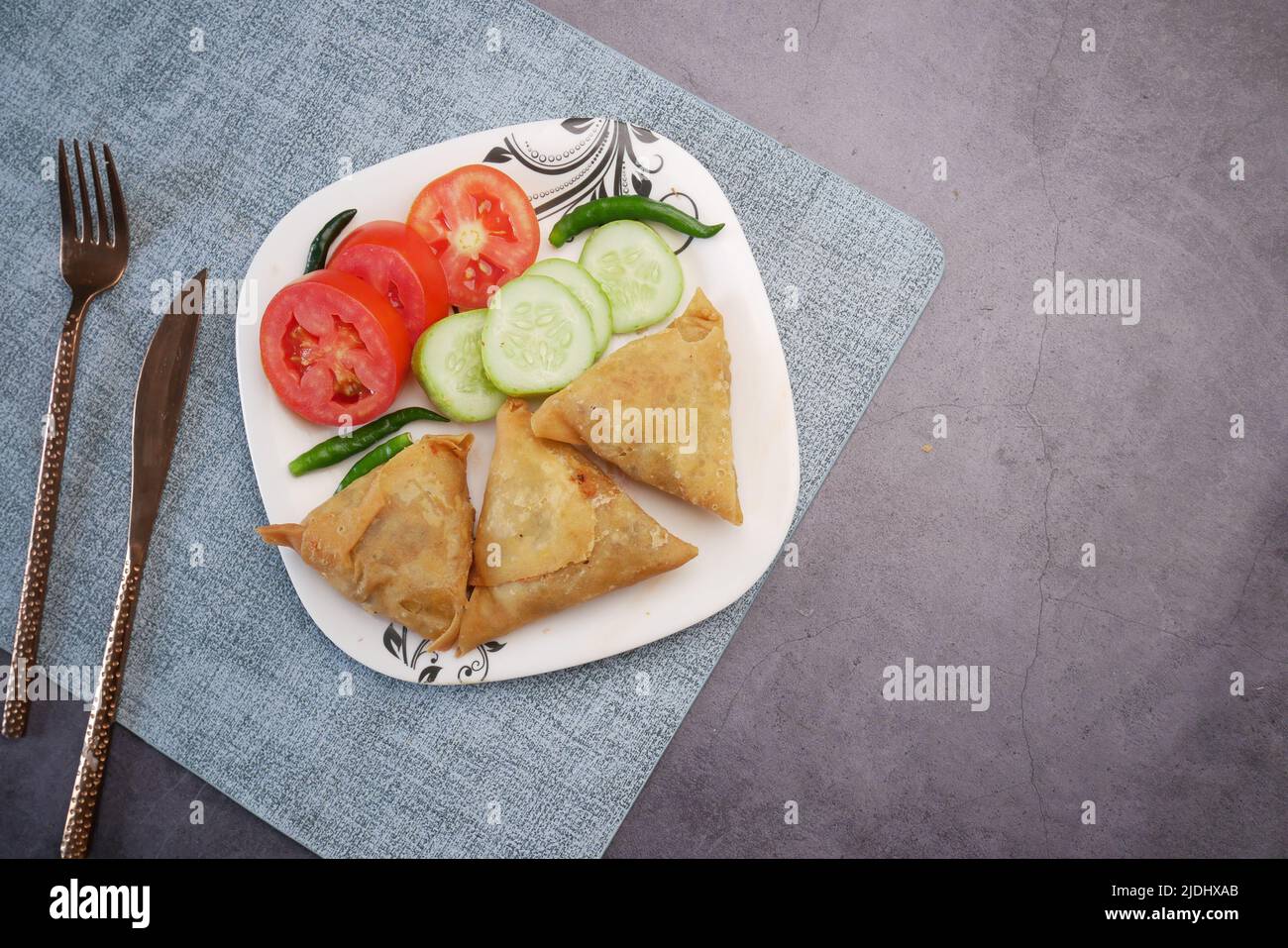 Vista dall'alto della samosa indiana e del pomodoro su un piatto Foto Stock
