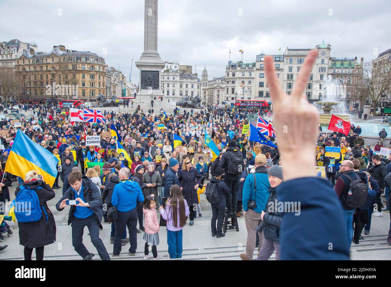 Un partecipante si accinge mentre le persone si riuniscono durante una protesta contro la recente invasione dell’Ucraina da parte della Russia a Trafalgar Square a Londra, Foto Stock