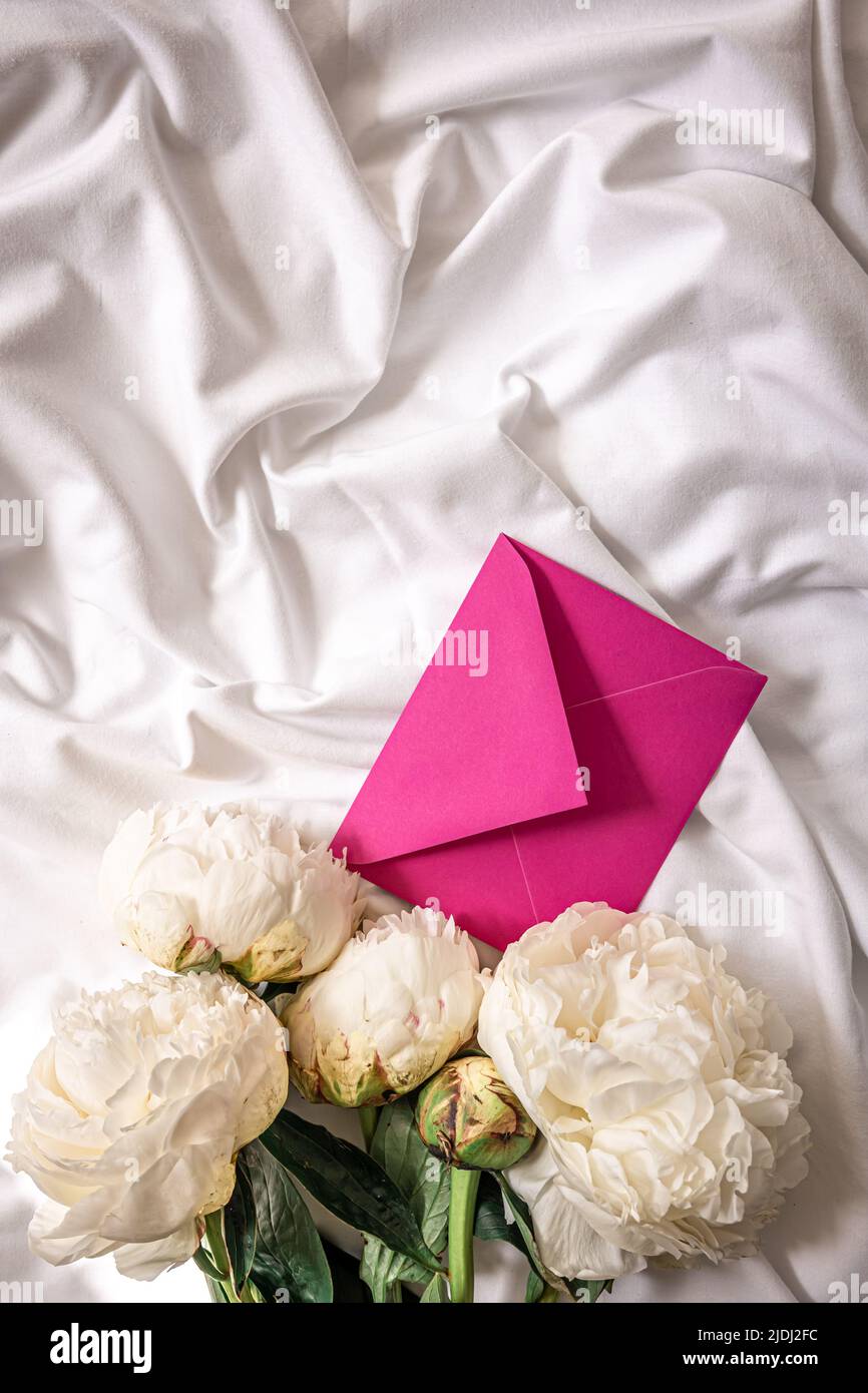 Sfondo con fiori peonie e buste a letto. Foto Stock