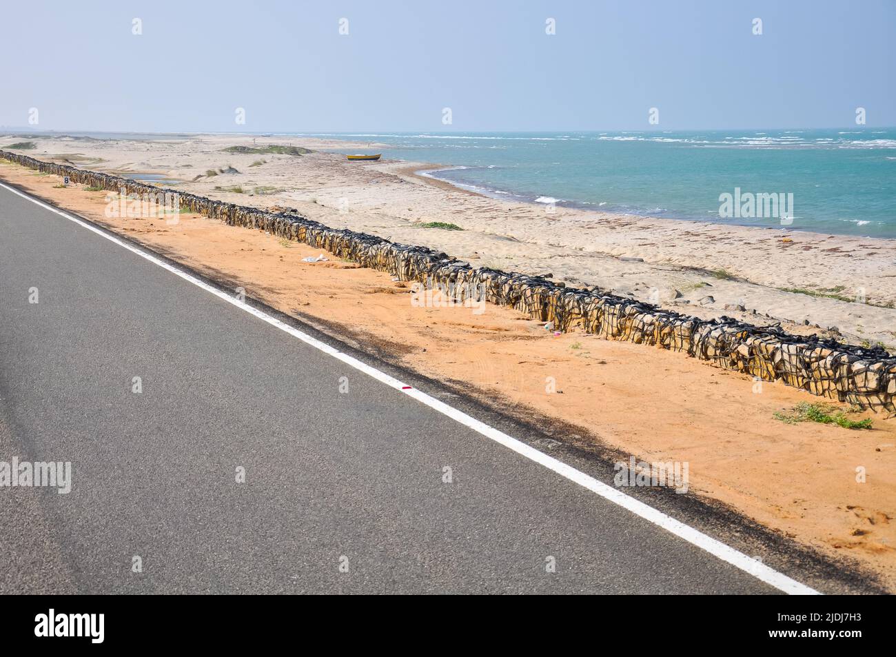 Strada asfaltata e spiaggia sabbiosa che domina l'Oceano Indiano a Arichal Munai, Dhanushkodi, Tamil Nadu, India Foto Stock
