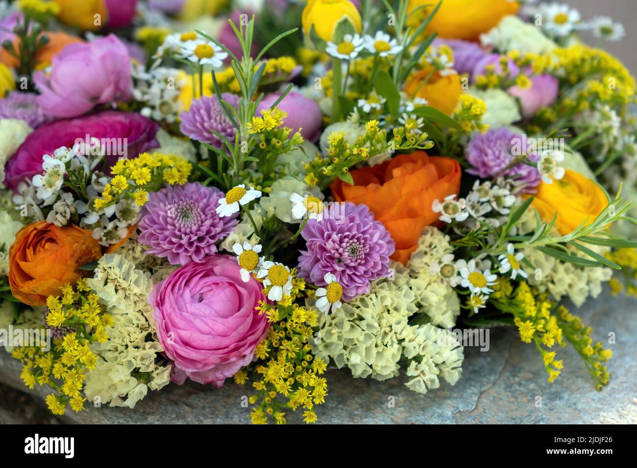 Vista ravvicinata della corona di fiori. Freschi fiori e erbe selvatiche colorate, giardino natura, primavera. Bouquet per la festa delle donne o delle madri Foto Stock