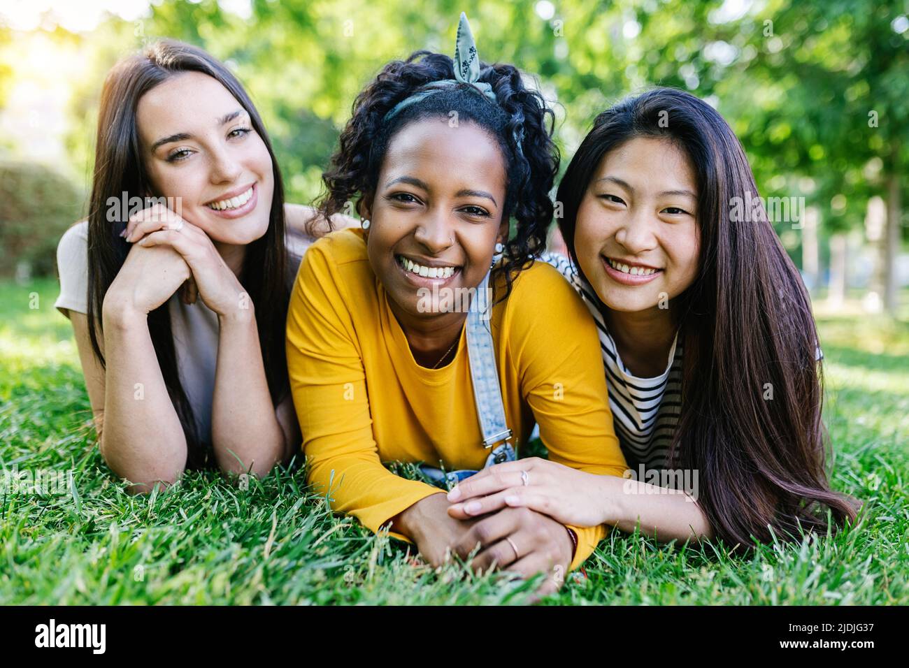 Ritratto gruppo di felice donna multirazziale amici sorridenti a fotocamera all'aperto Foto Stock