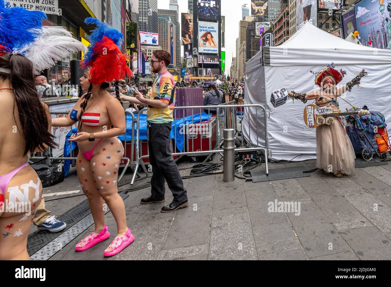 New York, Stati Uniti. 21st giugno 2022. Un mendicante senza casa e donne spaventa-blad cercano di ottenere i soldi dai passanti-vicino alla gente che partecipa ad una lezione libera di yoga a Times Square di New York City per celebrare la settima Giornata Internazionale di Yoga. Credit: Enrique Shore/Alamy Live News Foto Stock