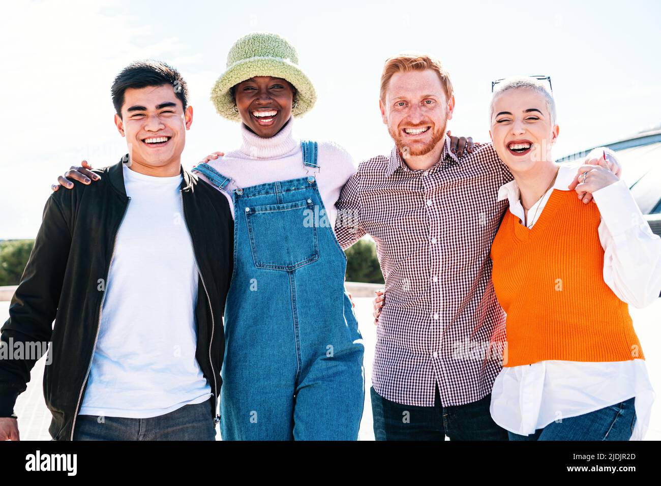 Ritratto di un felice gruppo multirazziale di amici sorridenti. I giovani ridono e si divertono nel parco in una giornata di sole Foto Stock