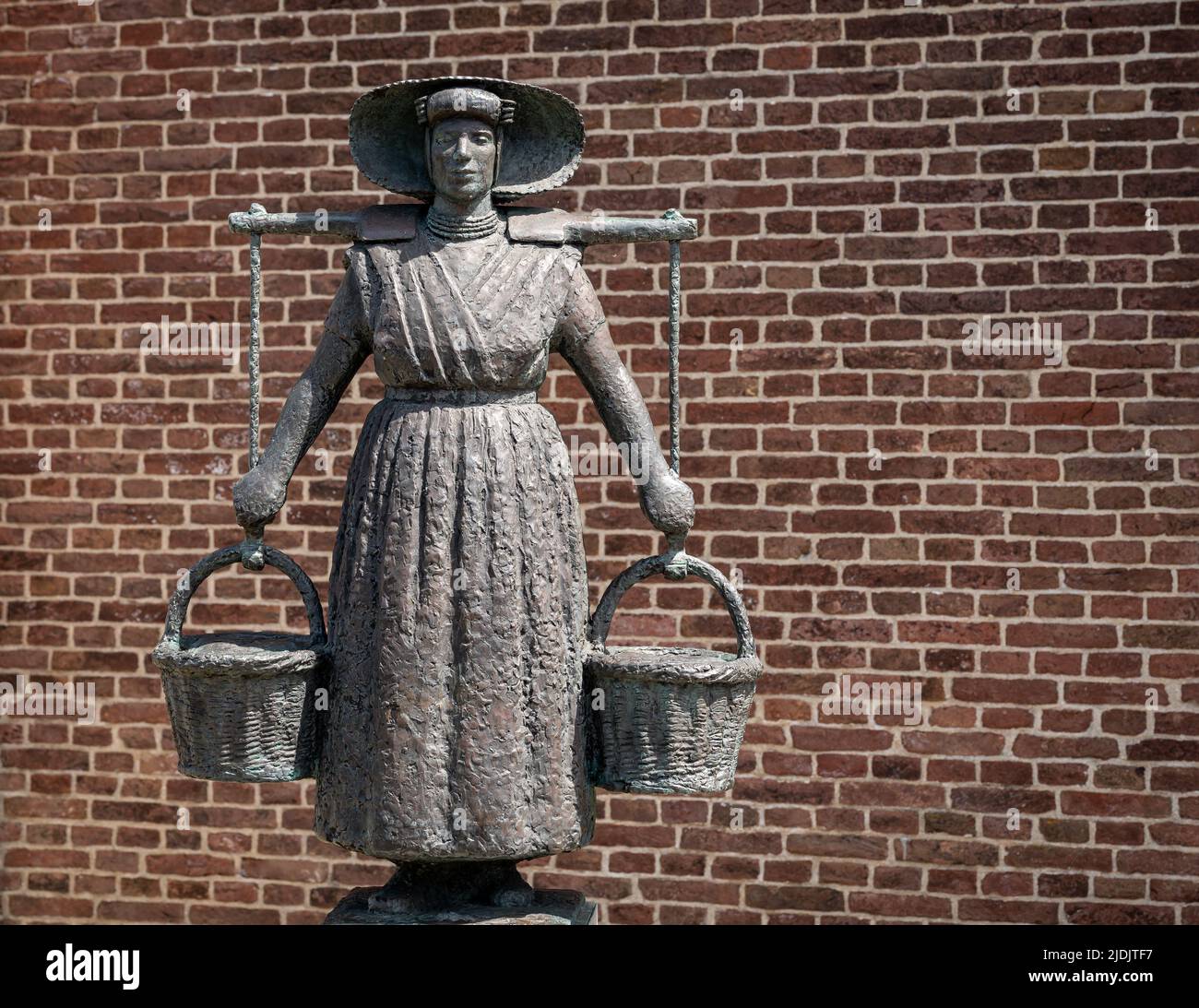 Arnemuiden, provincia Zeeland, Paesi Bassi, 21.05.2022, Statua della donna pescatore nel costume tradizionale di fronte alla chiesa Foto Stock