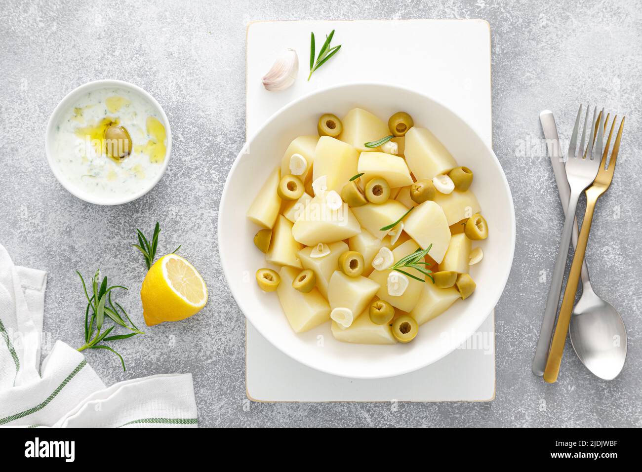 Patate bollite con aglio e olive e salsa tzatziki. Cibo sano. Dieta mediterranea Foto Stock