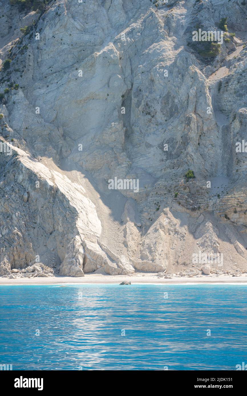 Bellissima spiaggia di ghiaia mediterranea sotto una grande roccia Foto Stock