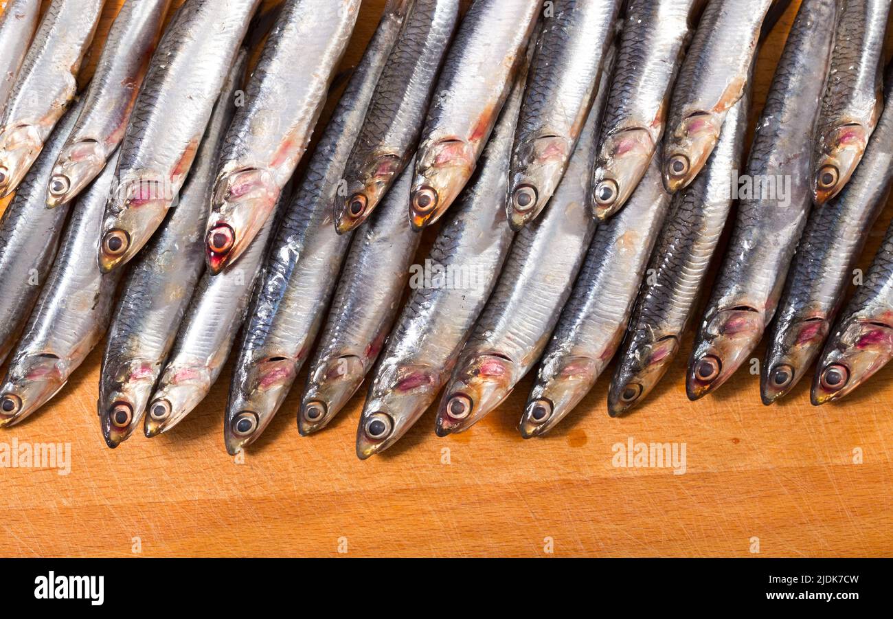 Acciughe europee salate su superficie in legno Foto Stock