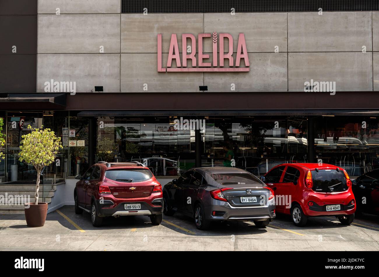 Facciata e ingresso del negozio di panetteria Lareira con alcune auto parcheggiate in una giornata di sole. Negozio situato in Sumare Avenue, all'angolo di Iperoig Street. Foto Stock